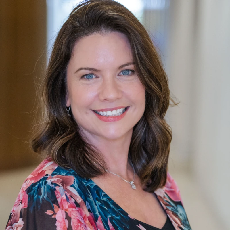 jacqueline limb 2026 - Eclipse Design Solutions Smiling woman with blue eyes and shoulder-length brown hair wearing a floral blouse, looking at the camera.